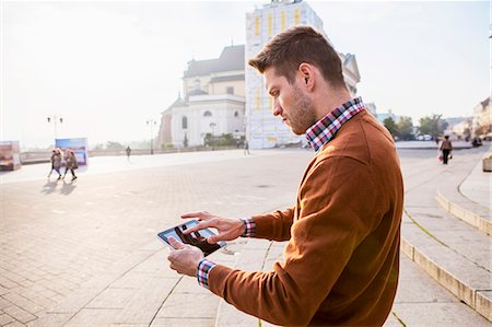 Man on a city break using touch screen Stock Photo - Premium Royalty-Free, Code: 6115-08416246