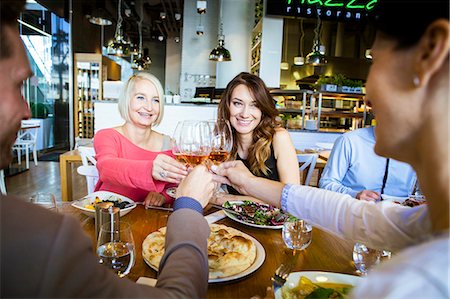 simsearch:6115-08416263,k - Group of friends celebrating in restaurant Stock Photo - Premium Royalty-Free, Code: 6115-08416272