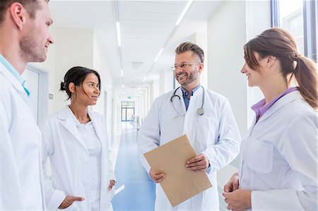 exam success - Doctor and coworkers talking in hospital corridor Stock Photo - Premium Royalty-Free, Code: 6115-08416205
