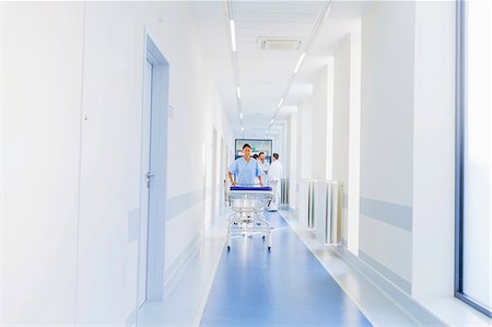 Healthcare worker pushing hospital gurney in corridor Stock Photo - Premium Royalty-Free, Code: 6115-08416211