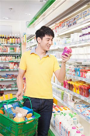 Smiling Young Man Looking At Food in Supermarket Stock Photo - Premium Royalty-Free, Code: 6116-06938549