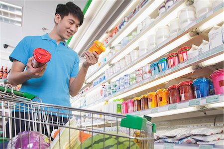 simsearch:6116-07085804,k - Young Man Making Decisions About Food in Supermarket Foto de stock - Sin royalties Premium, Código: 6116-06938550