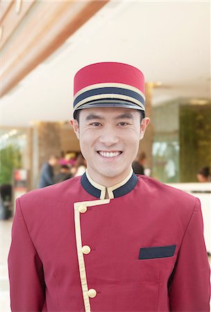 smiling chinese man with cap - Portrait of Bellhop Stock Photo - Premium Royalty-Free, Code: 6116-06938551