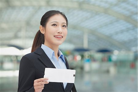 peking airport - Businesswoman at the airport with airplane ticket Stock Photo - Premium Royalty-Free, Code: 6116-06938513