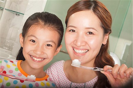 Mother and Daughter Brushing Teeth Together Stock Photo - Premium Royalty-Free, Code: 6116-06938720