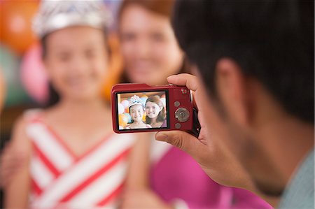 pink shirt woman - Father Taking a Picture of Mother and Daughter on Daughter's Birthday Stock Photo - Premium Royalty-Free, Code: 6116-06938732