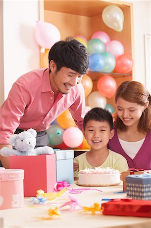 smiling people gifts - Family Celebrating Son's Birthday Stock Photo - Premium Royalty-Free, Code: 6116-06938737