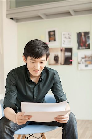 Professional Man Looking at Papers in Office Stock Photo - Premium Royalty-Free, Code: 6116-06938844