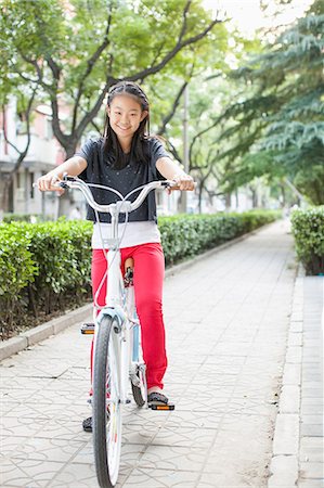 Young Girl Riding Her Bicycle Photographie de stock - Premium Libres de Droits, Code: 6116-06938828