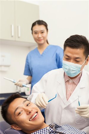 female dentist with gloves and mask - Male Dentist Examining Male Patient Foto de stock - Sin royalties Premium, Código: 6116-06938930