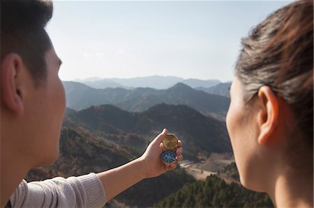 Young couple hiking and looking at the compass Foto de stock - Sin royalties Premium, Código: 6116-06939175