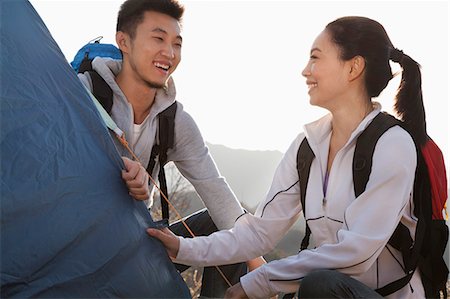 simsearch:6116-06939163,k - Young couple setting up the tent Stock Photo - Premium Royalty-Free, Code: 6116-06939184
