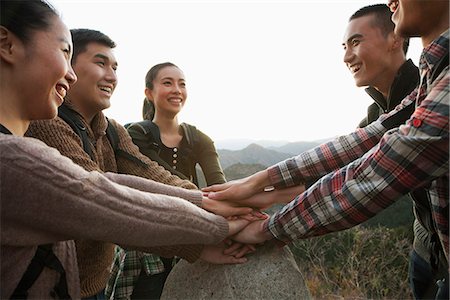 Group of young people smiling and holding hands together on the stone Stock Photo - Premium Royalty-Free, Code: 6116-06939194