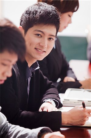 east asian meeting office - Office Worker Smiling and Looking at Camera Stock Photo - Premium Royalty-Free, Code: 6116-06939117