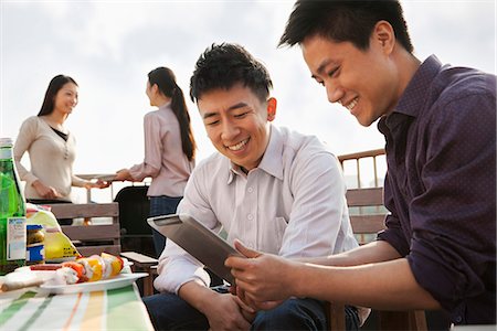 Friends Using Digital Tablet at Rooftop Barbecue Foto de stock - Sin royalties Premium, Código: 6116-06939241