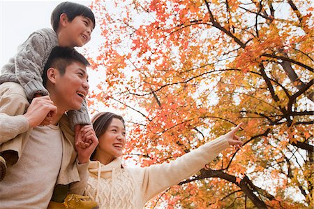 simsearch:6115-07539779,k - Family walking through the park in the autumn, little boy sitting on his fathers shoulders Stock Photo - Premium Royalty-Free, Code: 6116-06939270