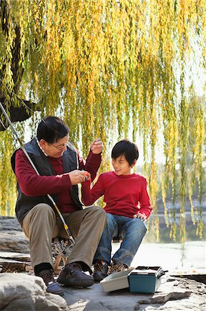 Grandfather and grandson putting lure on fishing line Foto de stock - Sin royalties Premium, Código: 6116-06939378