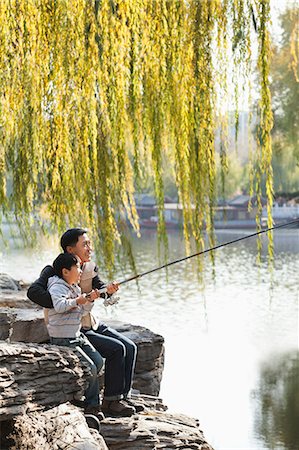 Father and son fishing together at lake Photographie de stock - Premium Libres de Droits, Code: 6116-06939384