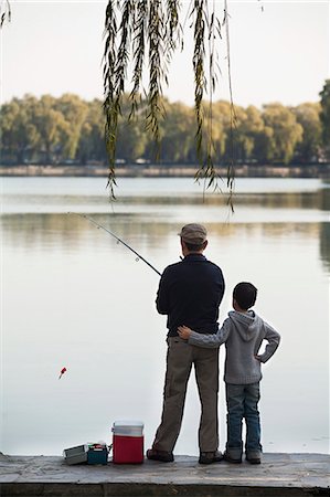 fischen - Grandfather and grandson fishing off of dock at lake Photographie de stock - Premium Libres de Droits, Code: 6116-06939392