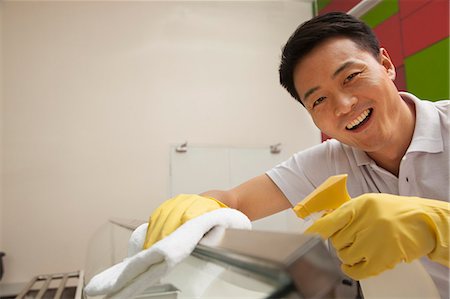 Cafeteria worker cleaning food serving area Stock Photo - Premium Royalty-Free, Code: 6116-06939483