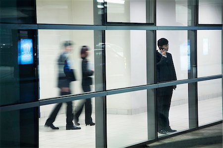 Businessman on the phone in parking garage, looking through window Photographie de stock - Premium Libres de Droits, Code: 6116-06939425