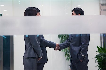 simsearch:6116-06939585,k - Three business people meeting and shaking hands, seen through glass wall Photographie de stock - Premium Libres de Droits, Code: 6116-06939438