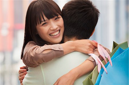 simsearch:6116-07235750,k - Young couple embracing with shopping bags, outdoors, Beijing Foto de stock - Sin royalties Premium, Código: 6116-07084507