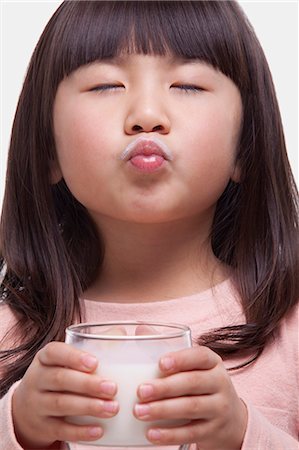 Portrait of girl drinking a glass of milk, making a face Photographie de stock - Premium Libres de Droits, Code: 6116-07084696