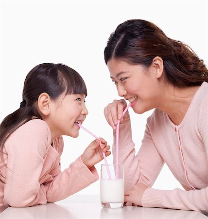 paille (à boire) - Mother and daughter sharing a glass of milk, studio shot Photographie de stock - Premium Libres de Droits, Code: 6116-07084698