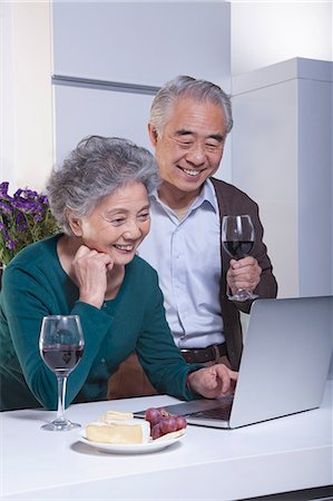 simsearch:614-06895865,k - Mature Couple Looking at Laptop in the Kitchen, Drinking Wine Photographie de stock - Premium Libres de Droits, Code: 6116-07084748