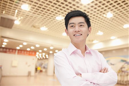 simsearch:6116-07086481,k - Portrait of young businessman in button down shirt with arms crossed, indoors Stock Photo - Premium Royalty-Free, Code: 6116-07084755