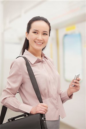 simsearch:6116-07235912,k - Smiling young woman holding mobile phone Photographie de stock - Premium Libres de Droits, Code: 6116-07084777