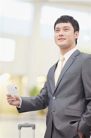 Smiling business man holding flight ticket Stock Photo - Premium Royalty-Free, Code: 6116-07084797