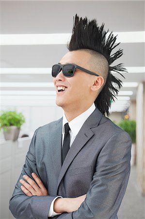 rocker - Well-dressed young man with Mohawk and sunglasses smiling Stock Photo - Premium Royalty-Free, Code: 6116-07085099