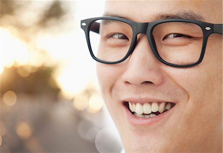 simsearch:6116-07086707,k - Young man with glasses smiling close-up Stock Photo - Premium Royalty-Free, Code: 6116-07085102