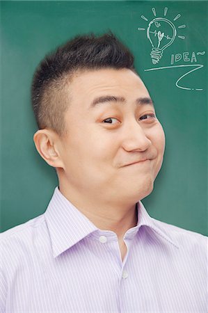 simsearch:6116-07085230,k - Portrait of young man with an idea in front of a blackboard Stock Photo - Premium Royalty-Free, Code: 6116-07085218