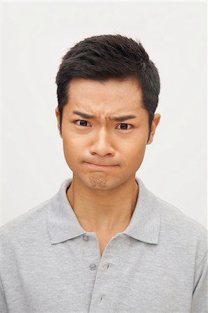 Portrait of angry and frustrated young man, studio shot Stock Photo - Premium Royalty-Free, Code: 6116-07085229