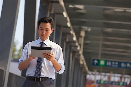 picture on subway - businessman working on his digital tablet near the subway station Stock Photo - Premium Royalty-Free, Code: 6116-07085413