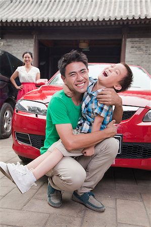 family playing outdoors parent ethnic not beach not park - Father and Son Wrestling Stock Photo - Premium Royalty-Free, Code: 6116-07085544