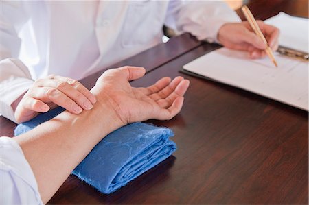 Close Up of Patient's Hand While Doctor Takes Pulse Stock Photo - Premium Royalty-Free, Code: 6116-07085535