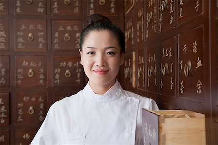 Portrait of Doctor In Front of Traditional Chinese Medicine Cabinet Stock Photo - Premium Royalty-Free, Code: 6116-07085627