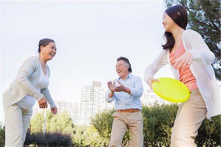 extended family - Granddaughter with grandparents playing Frisbee in the park Stock Photo - Premium Royalty-Free, Code: 6116-07085946