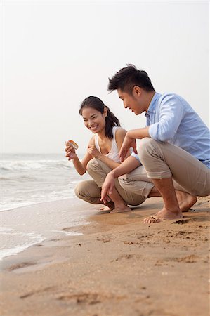simsearch:6116-07085909,k - Young couple looking at seashell at the waters edge, China Stock Photo - Premium Royalty-Free, Code: 6116-07085904