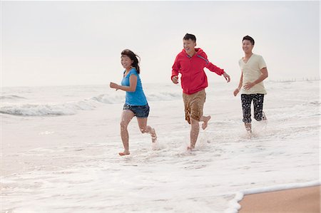 simsearch:6116-07085909,k - Three friends running on the beach by the waters edge, China Stock Photo - Premium Royalty-Free, Code: 6116-07085921