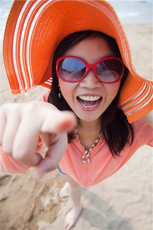 simsearch:6116-07085909,k - Smiling women standing on the beach pointing at camera, portrait Stock Photo - Premium Royalty-Free, Code: 6116-07085930