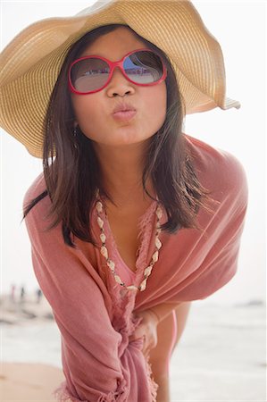 sunhat - Portrait of women on the beach making kissing face at the camera Stock Photo - Premium Royalty-Free, Code: 6116-07085931