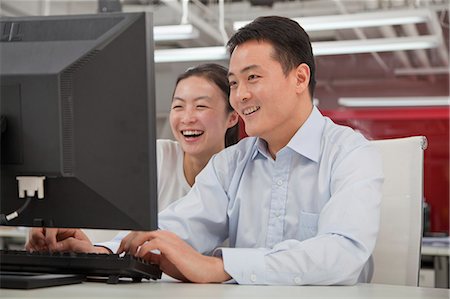 Happy business people working on their computer in the office Stock Photo - Premium Royalty-Free, Code: 6116-07086182