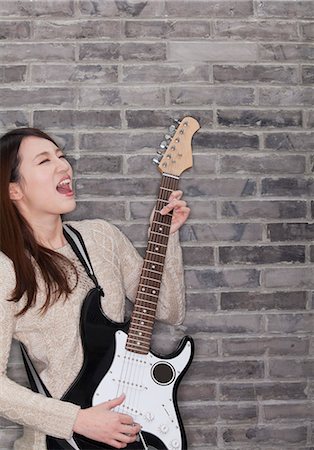 simsearch:685-02940297,k - Young Woman Playing a Electric Guitar Foto de stock - Royalty Free Premium, Número: 6116-07086251