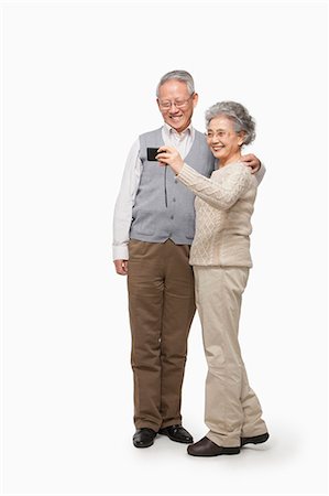 senior on white background - Senior couple taking picture with digital camera Stock Photo - Premium Royalty-Free, Code: 6116-07086261