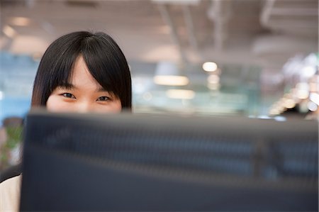 simsearch:614-06974353,k - Young Businesswoman Looking over Computer in the Office Stock Photo - Premium Royalty-Free, Code: 6116-07086217